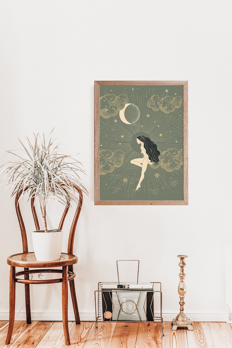 May include: A framed print with a green background and gold accents. The print features a woman with long dark hair sitting on a cloud with a crescent moon and stars in the background.