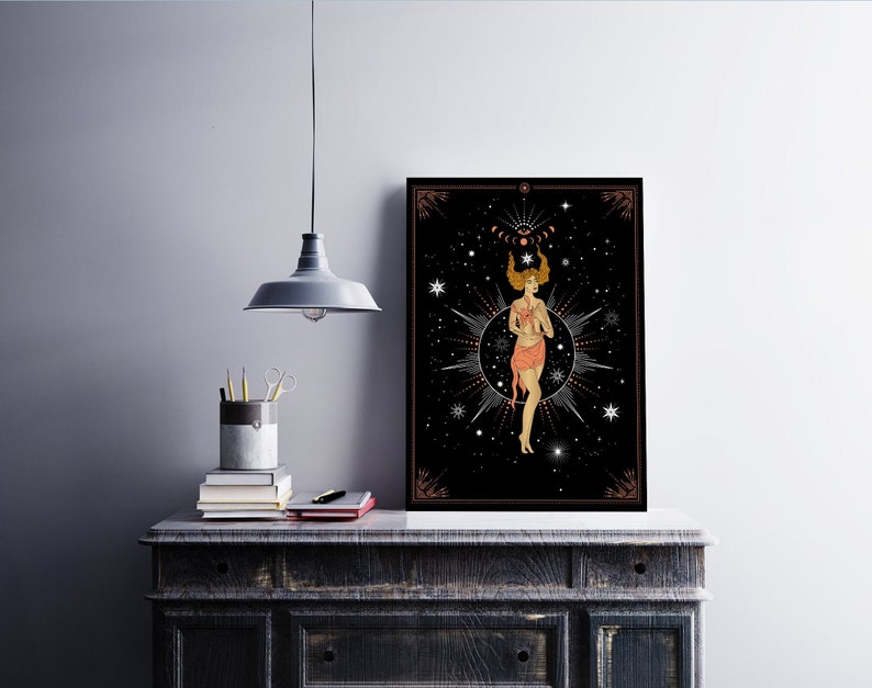 以下が含まれることがあります： 黒と金のフレームに入った、天体模様のプリント。星とピンクのドレスを身につけた女性が、星と月の円の中心に立っています。背景は黒で、白い星が散りばめられています。
