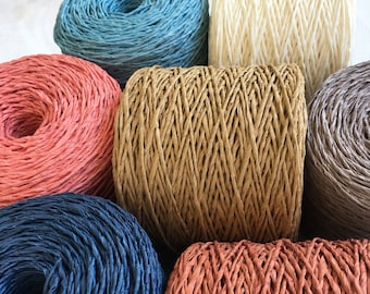 May include: Assortment of six spools of colourful paper cord. The cords are twisted and have a rope-like texture. The colours are blue, red, brown, grey, cream, and a darker blue.