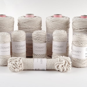 Puede incluir: Una colección de bobinas de cuerda de algodón blanquecino y un trozo de cuerda. Las bobinas, de varios tamaños, están etiquetadas con la marca "clowex". La cuerda está bien enrollada y tiene un aspecto natural y texturizado, ideal para manualidades.