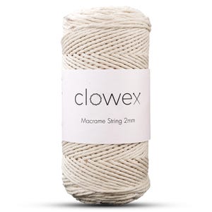 Puede incluir: Un carrete de hilo macramé blanquecino. Una etiqueta blanca alrededor del centro muestra la marca "clowex" y el texto "Macrame String 2mm". El hilo parece estar hecho de fibras naturales, adecuado para proyectos de manualidades.