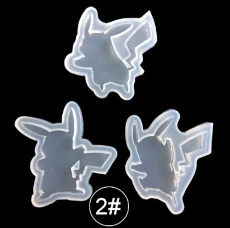 May include: Three clear silicone molds in the shape of a Pikachu character. The molds are on a black background. The number "2#" is printed in a white circle on the bottom of the image.