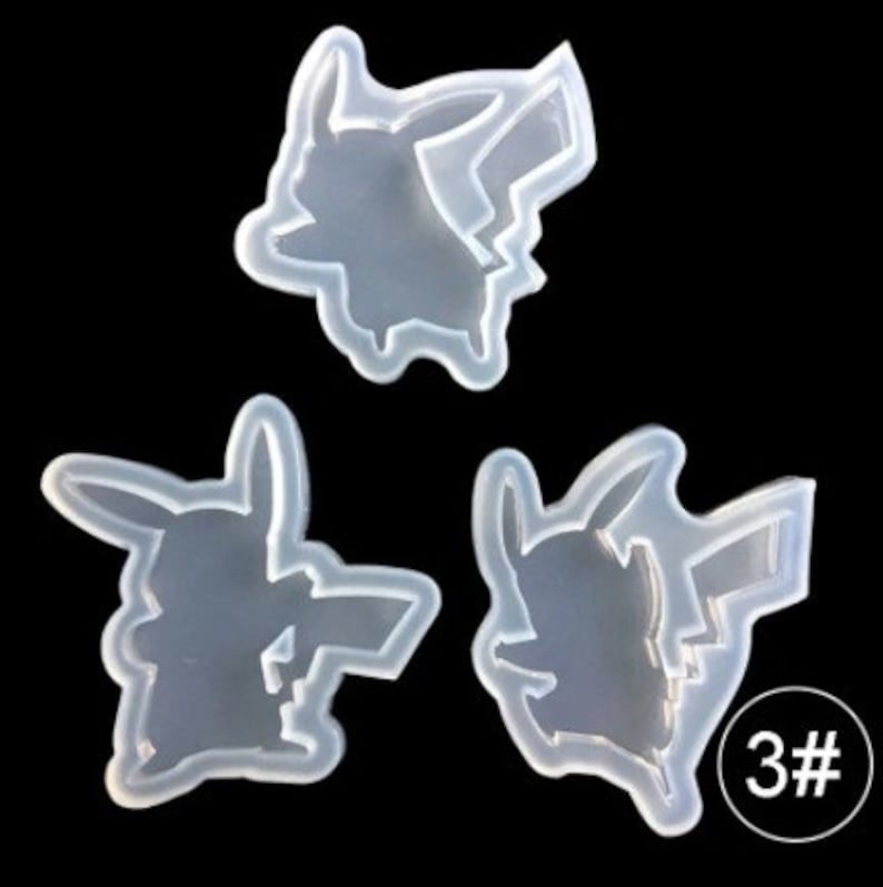 May include: Three clear silicone molds in the shape of Pikachu, a popular cartoon character. The molds are arranged against a black background. One mold has the number "3#" in a white circle.