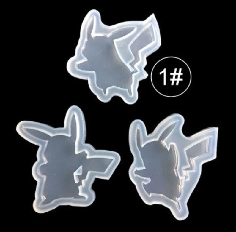 May include: Three clear silicone molds in the shape of Pikachu, a popular cartoon character. The molds are arranged on a black background. One mold has the number "1#" in a white circle.