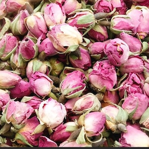 Könnte beinhalten: Nahaufnahme eines Haufens getrockneter Rosenknospen. Die Knospen zeigen Schattierungen von Rosa und Magenta, mit einem Hauch von Beige und Grün. Das Bild ist dicht mit den getrockneten Blüten gefüllt, was auf eine große Menge hindeutet.