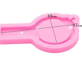 May include: A pink silicone mold for crafting, shaped like a lollipop or a key. The mold is 8.7 cm long and 4.9 cm wide. Ideal for creating resin or polymer clay charms and pendants.