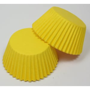 May include: Two yellow cupcake cases, made of paper, with a fluted design.