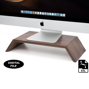 May include: A dark brown wooden monitor stand with a curved front edge. The stand is designed to elevate a computer monitor, creating a more ergonomic workspace.