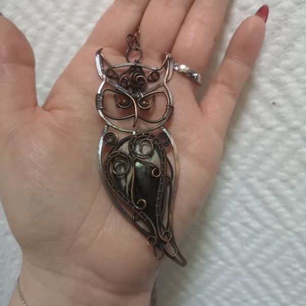 Le collier pendentif hibou des forêts réalise avec une racine de palmier focille .