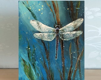 May include: A painting of a dragonfly with translucent wings against a blue background with green and brown brushstrokes. The dragonfly is perched on a stalk of grass.