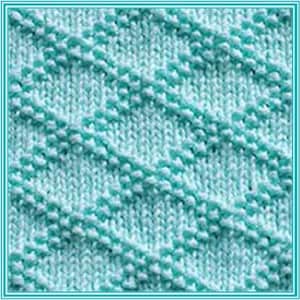 May include: A close-up of a light blue knitted fabric with a diagonal pattern. The fabric has a textured surface and a soft, fuzzy appearance.