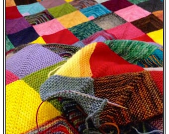 May include: A colorful knitted blanket with a variety of squares in different colors, including red, yellow, blue, green, and purple. The blanket is being worked on with a knitting needle and yarn.