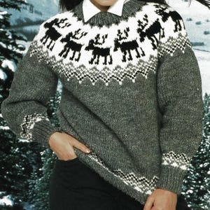 May include: A gray knit sweater with a white collar and a reindeer pattern across the chest. The reindeer are black and white, with a zig-zag pattern at the bottom of the reindeer design. The sleeves and bottom hem have a white and black zig-zag pattern.