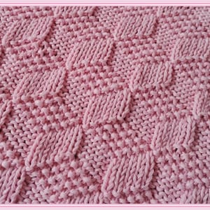 May include: A close-up of a pink knitted fabric with a diamond pattern.