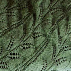 May include: Close-up of a knitted green textile with a leaf-like pattern. The intricate design features openwork details and textured stitches, creating a visually appealing and tactile surface. The fabric appears soft and pliable.