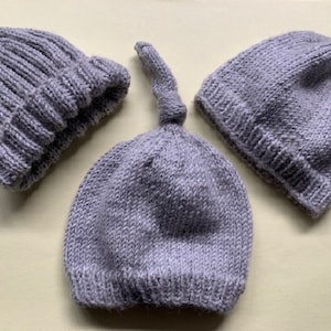 May include: Three grey knitted hats. Two of the hats are beanie style and one is a slouchy hat.