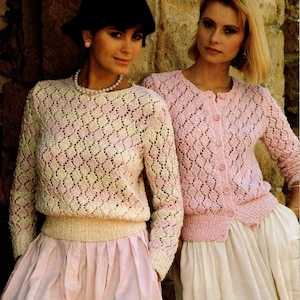 Puede incluir: Dos mujeres con suéteres de crochet rosa y blanco. Los suéteres tienen un patrón de diamante y son de abertura frontal. Las mujeres están de pie una al lado de la otra y miran a la cámara.