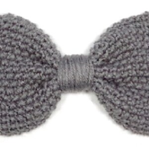 May include: A gray knitted bow tie. The bow tie is made of a soft, textured yarn.