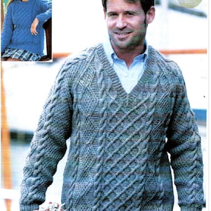 May include: A blue knitted sweater with a v-neck and a cable knit pattern. The sweater is shown on a model with a casual, relaxed look. The text "Includes larger sizes" is visible in the upper right corner of the image.