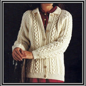May include: A white knitted cardigan with a cable knit pattern and button fastening. The cardigan has a collared neckline and long sleeves.