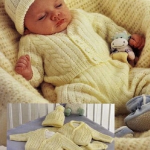 May include: A knitted baby outfit in a pale yellow color. The outfit includes a hat, cardigan, pants, and booties. The outfit is laid out on a light blue surface.