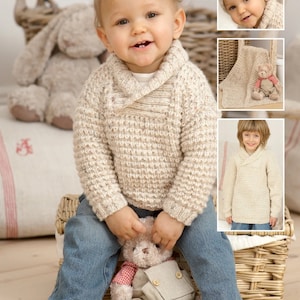 Könnte beinhalten: Ein cremefarbener Strickpullover mit Schalkragen für ein Baby. Der Pullover hat ein strukturiertes Strickmuster und wird auf einem Baby in blauer Jeans gezeigt.
