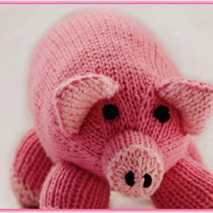 May include: A knitted pink pig toy, featuring black button eyes and a detailed snout. The pig has large ears and four stubby legs, all made from soft yarn. This handmade toy is designed as a cuddly and charming item for children.