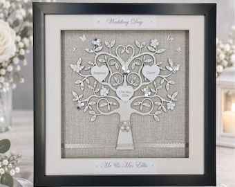 May include: A framed shadow box featuring a white tree cutout on a beige linen background. The tree includes heart-shaped cutouts with the names Stephen and Claire and the date 17th May 2026. Text reads Wedding Day and Mr & Mrs Ellis.
