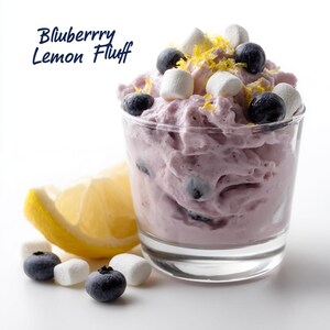 Puede incluir: Un postre de crema de limón y arándanos en un vaso, con arándanos, malvaviscos y ralladura de limón. El postre es de color morado claro. Una rodaja de limón, arándanos y malvaviscos están al lado del vaso. El texto "Bluberry Lemon Fluff" está en la imagen.