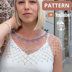 Peut inclure: Un châle en perles fait à la main, en mailles ajourées, dans les tons de blanc, de bleu et d'argent. Le design délicat en forme de filet est porté sur un haut blanc. Le mot "PATTERN" est affiché dans un encadré marron, avec les icônes YouTube et PDF.