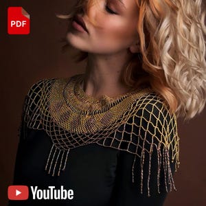 Peut inclure: Un châle en perles dorées et bronze, avec un motif en filet et des franges, porté sur un haut noir. L'image comprend une icône PDF et le logo YouTube. Fond marron chaud.