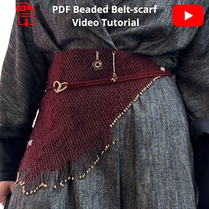 May include: A burgundy beaded belt-scarf with gold-colored accents. The belt features a woven design with a triangular scarf element. The image includes the text "PDF Beaded Belt-scarf Video Tutorial".