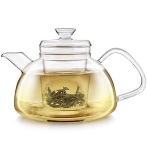 May include: A clear glass teapot with a curved handle and spout. The teapot is filled with a light yellow liquid and contains a removable infuser basket filled with green tea leaves. The lid is also made of clear glass.
