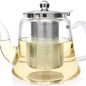 May include: A set of three ceramic mugs with a speckled, matte finish. The mugs are in shades of cream, light gray, and dark gray. Each mug has a simple, minimalist design and a rounded handle.