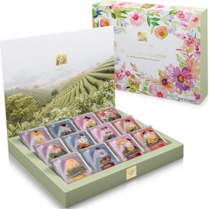 May include: A green box with a floral design on the lid. The box contains 12 individual tea bags, each with a different flower inside. The tea bags are arranged in a grid pattern. The box is labeled "Blooming Tea Garden" and "Teabloom".