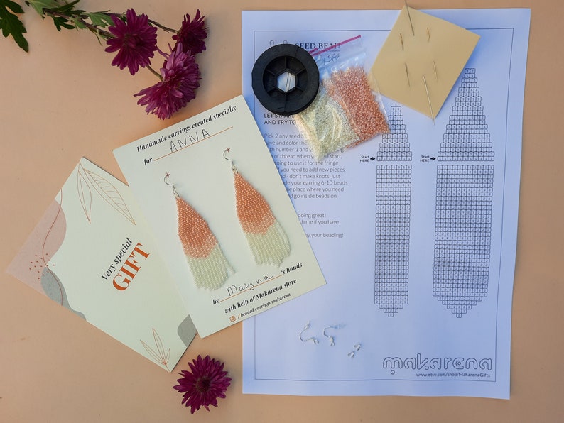 May include: A beading kit for making earrings. The kit includes beads in white and peach colors, two earring findings, a needle, thread, and a pattern. The kit is labeled "Handmade earrings created specially for ANNA" and "Very special GIFT".