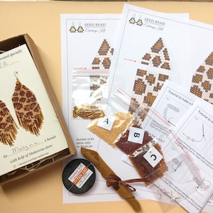 May include: A kit for making beaded earrings with a leopard print design. The kit includes seed beads in brown, gold, and white, gold-colored beading needles, and a printed instruction sheet with the title "Seed Bead Earrings Kit".