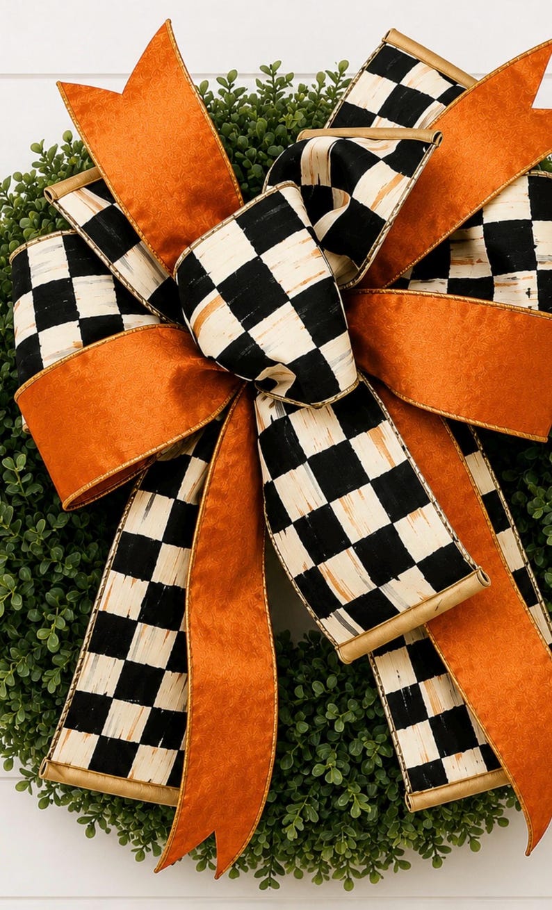 May include: A decorative bow featuring alternating ribbons of solid burnt orange and a black and white checkered pattern. The bow is layered with multiple loops and long, flowing tails, secured in the center, and positioned atop a green wreath.