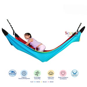 May include: A multi-coloured fabric sensory swing hammock featuring bright blue, red, and yellow panels with black reinforced ends. The text "Sensory Thera Haus" is visible in the upper right corner, along with icons for play, move, relax, and grow.