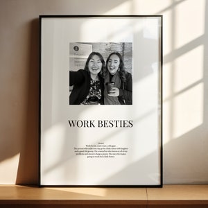 May include: Black and white photo print of two women smiling and holding coffee cups. The print is framed in a black frame and has the text "WORK BESTIES" and a definition of the term.