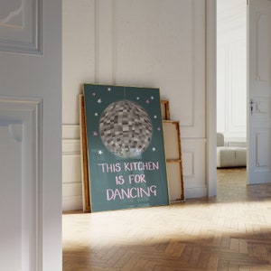 May include: A teal blue poster with a silver disco ball and the text "This kitchen is for dancing" in pink.