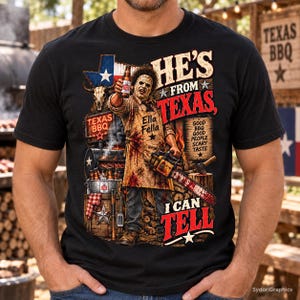 May include: A black t-shirt featuring a graphic of a character wearing a blood-stained apron labeled Ella Fella, holding a bottle and a chainsaw. The design includes a Texas flag, a skull, a grill, and text reading HE'S FROM TEXAS, I CAN TELL.