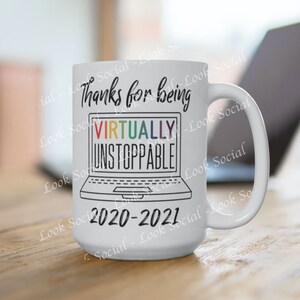 May include: White ceramic mug with a black outline of a laptop and the text "Thanks for being VIRTUALLY UNSTOPPABLE 2020-2021". The text "VIRTUALLY" is in rainbow colors.