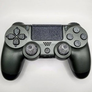 May include: A black PlayStation 4 controller with a sparkly, textured finish. The controller has a black and white button layout and a black and white touchpad.