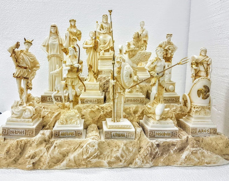 以下が含まれることがあります： 12体のギリシャ神々を表現した白い大理石の彫刻セット。各像は、それぞれの名前が刻まれた岩場の上に配置されています。セットには、ヘルメス、アルテミス、アポロン、アフロディーテ、アテナ、ポセイドン、アレス、ヘスティア、デメテル、ゼウス、ヘラ、ハデスが含まれています。