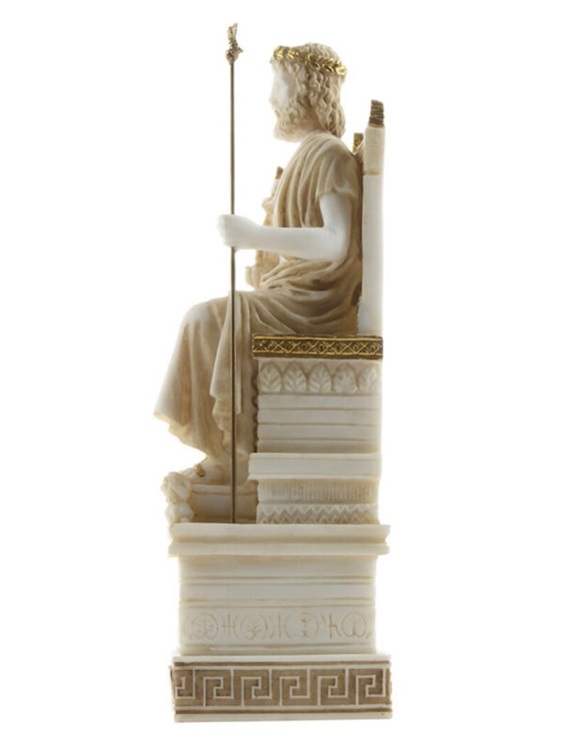 Op de afbeelding: Wit marmeren beeld van Zeus, de Griekse god van de hemel en de donder, zittend op een troon. Hij draagt een kroon van bladeren en houdt een scepter vast. Het beeld staat op een witte marmeren sokkel met gouden accenten.