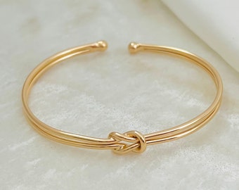 Peut inclure: Un bracelet jonc double en or avec un nœud.