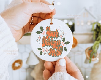 Peut inclure: Ornement de Noël en céramique blanche avec un motif de feuilles de houx vertes et le texte "Your Design Here" en lettres roses et orange.