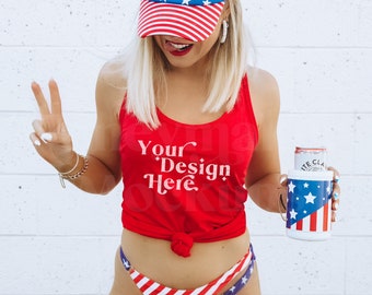 Könnte beinhalten: Ein rotes Tanktop mit dem Text "Your Design Here" in Weiß. Das Tanktop ist in der Taille gebunden. Die Person trägt eine rot-weiß-blaue Mütze mit Sternen- und Streifenmuster und einen passenden Bikini-Unterteil. Die Person hält eine weiße Getränkedose mit einem rot-weiß-blauen Sternen- und Streifenmuster.