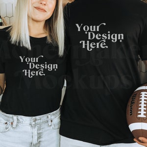 May include: Two people wearing black t-shirts with the text "Your Design Here" printed on them. The woman is holding a can of sparkling water and the man is holding a brown and white football.